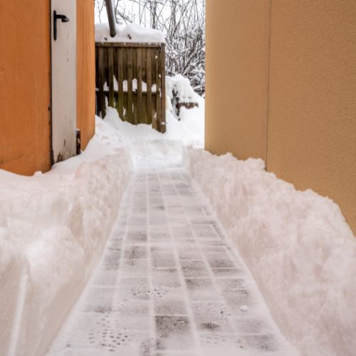 Freigeräumter Gehweg zwischen Schneewällen in Kaarst